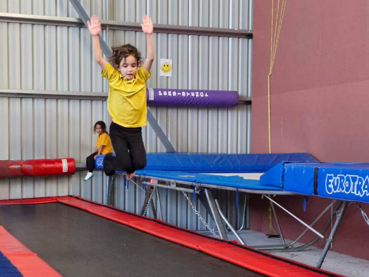 A girl jumping on a trampoline.