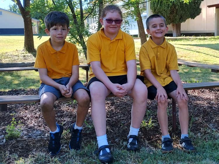 Three students sitting together in the playground.