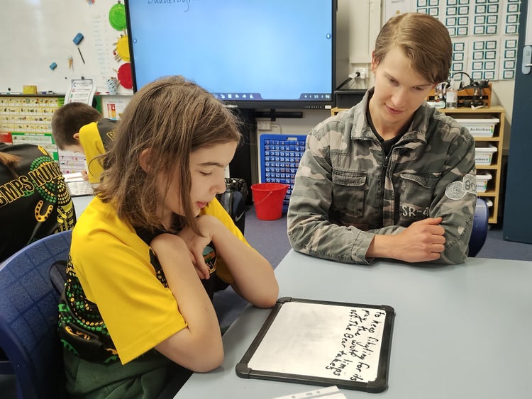 A School Learning Support Officer works with a student.