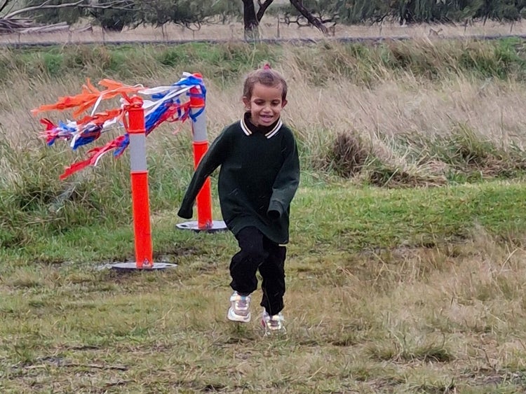 A girl runs towards the finish line.