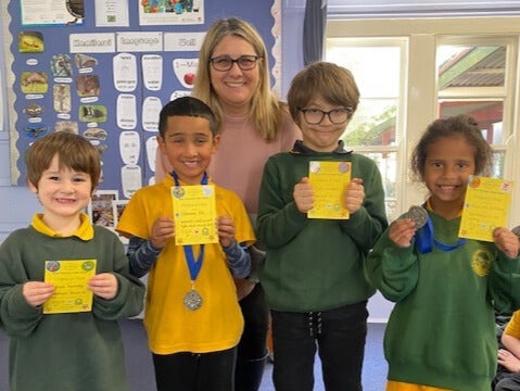 Four students holding their assembly awards.