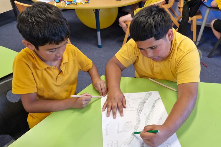 Two boys are drawing together.
