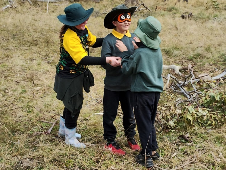 3 students playing a blindfold game.